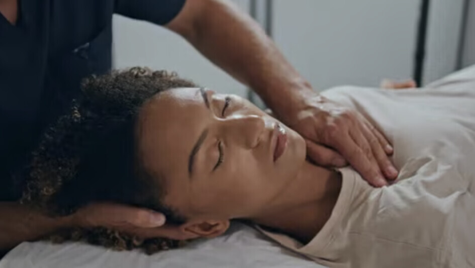 Alt Text for Image: A close-up shot of hands gently massaging the neck and shoulder area, illustrating myofascial release and neuro-somatic pain therapy at QiKiSol.